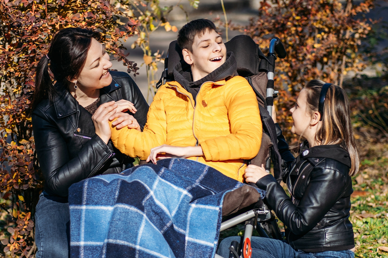Happy family with a smiling special needs child in a stroller
