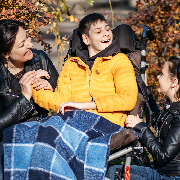 Happy family with a smiling special needs child in a stroller