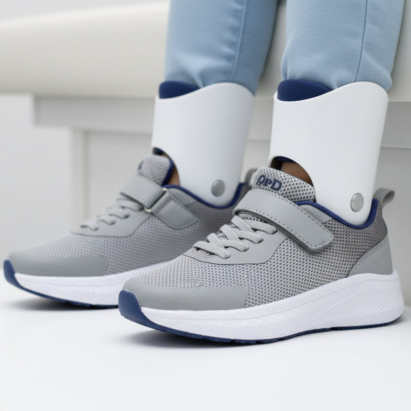 Person wearing gray sneakers with white socks on a light background